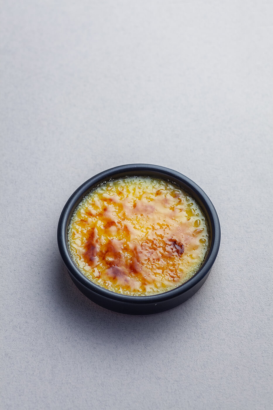 Crema catalana z warstwą skarmelizowanego cukru w miseczce.