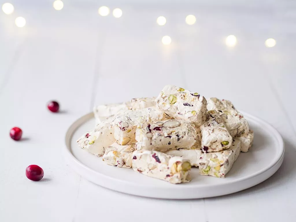 Waniliowy nugat z orzechami i żurawiną na białym talerzyku - Wszystkiego Słodkiego