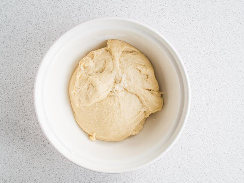 wyrobione ciasto drożdżowe na pączki z lemon curd w misce