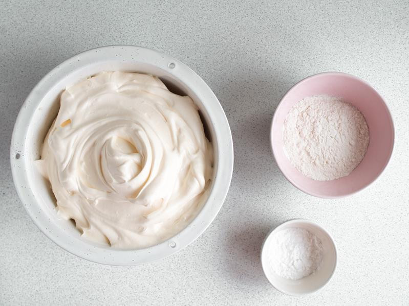 jajka ubite z cukrem w misce, obok dwie miseczki z mąką pszenną i mąką ziemniaczaną