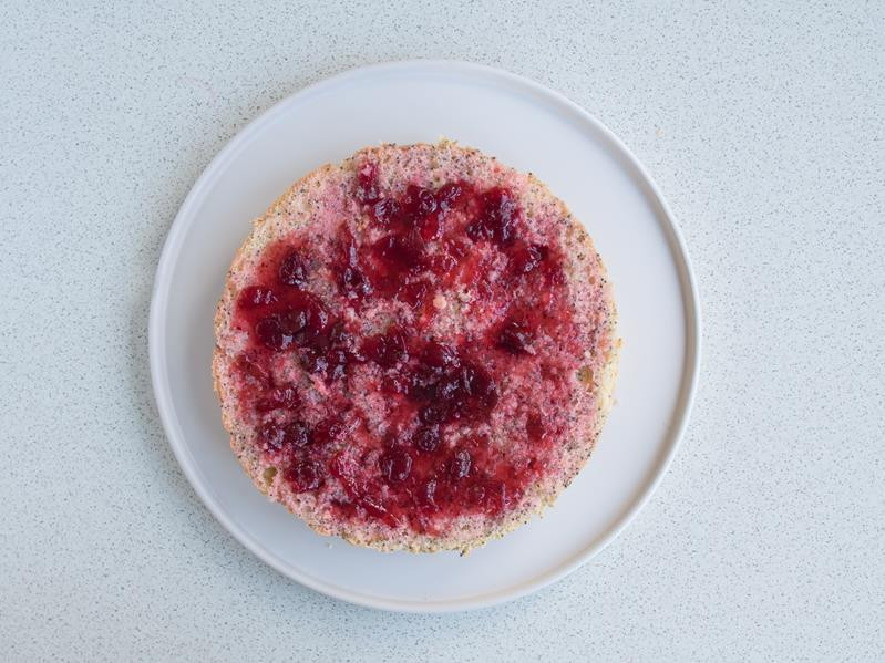 jeden z blatów biszkoptu makowego posmarowany konfiturą żurawinową