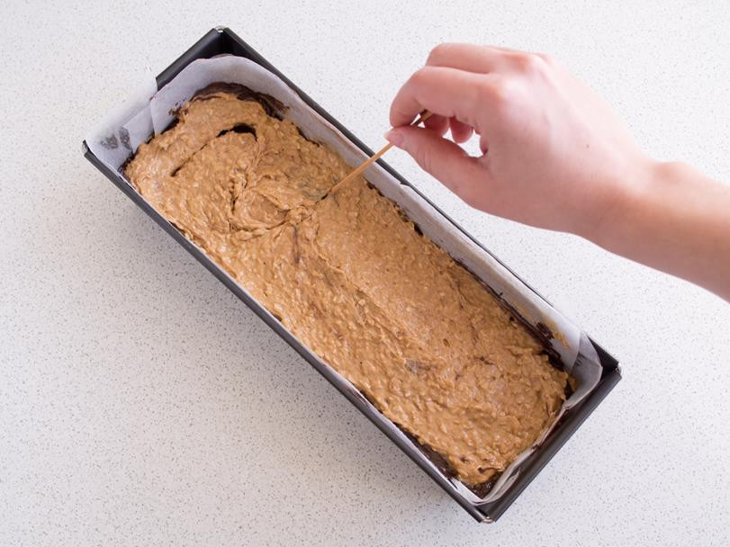 ciasto na babkę marmurkową kokosowo-czekoladową wyłożone do keksówki, robienie zygzaków patyczkiem na cieście