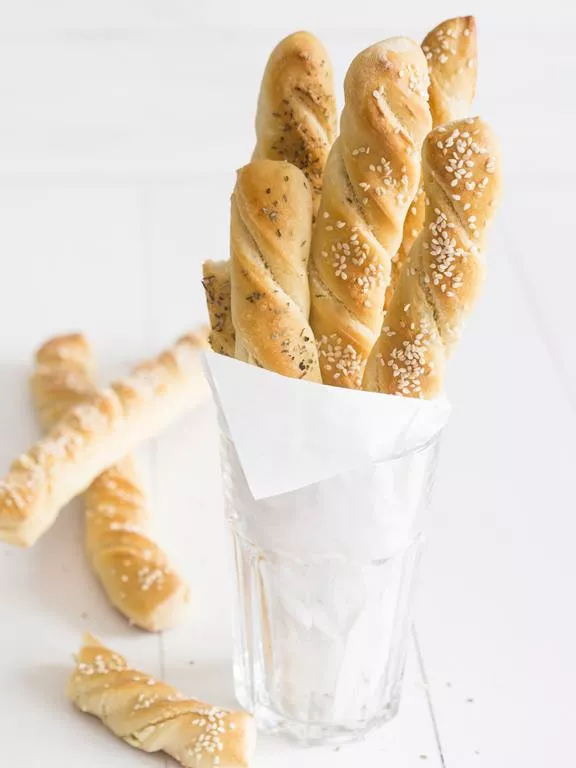 drozdzowe paluchy z serkiem ziołowym owiniete papierem w szklance