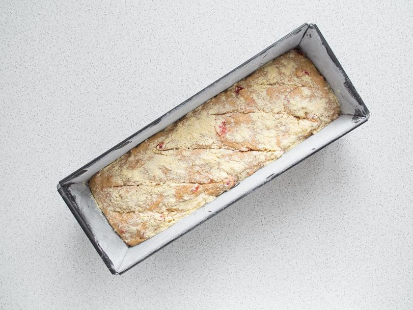 ciasto na chleb paprykowy w formie, nacięte i obsypane mąką kukurydzianą gotowe do pieczenia