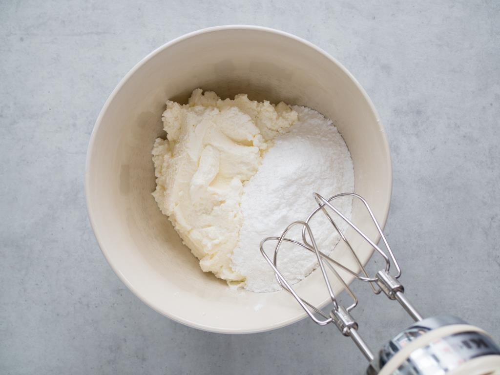 Serek ricotta wymieszany z cukrem w misce z mikserem