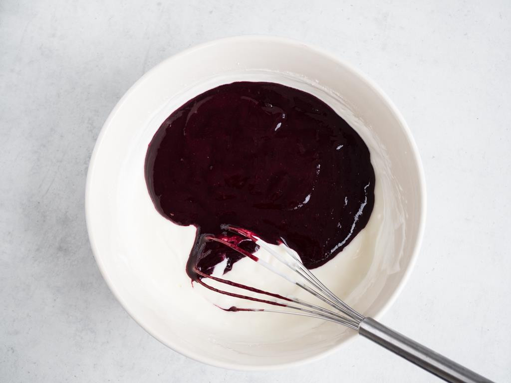 Jogurt z cukrem pudrem wymieszany z puree porzeczkowym w miseczce