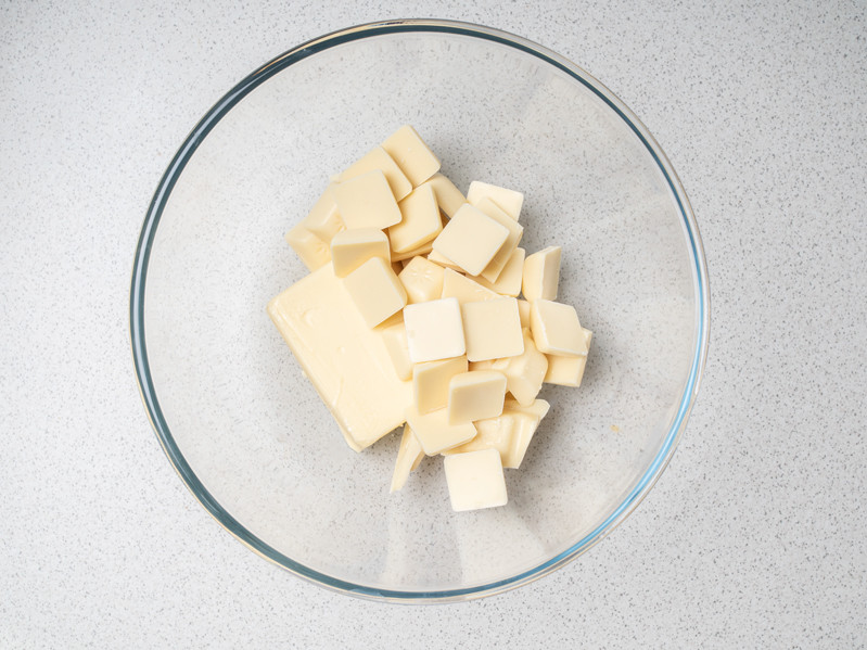 pokrojone w kostkę masło z białą czekoladą w szklanej misce
