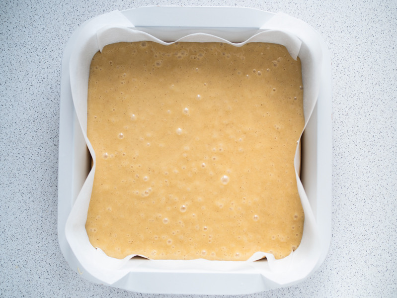 ciasto na blondie w formie do pieczenia wyłożonej białym papierem do pieczenia