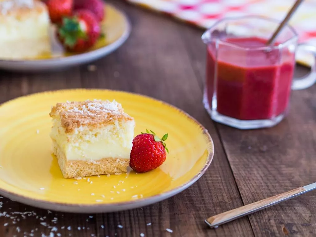 ciasto kokosowe z budyniową i kokosową pianką z sosem truskawkowym w szklance obok - wszystkiego słodkiego