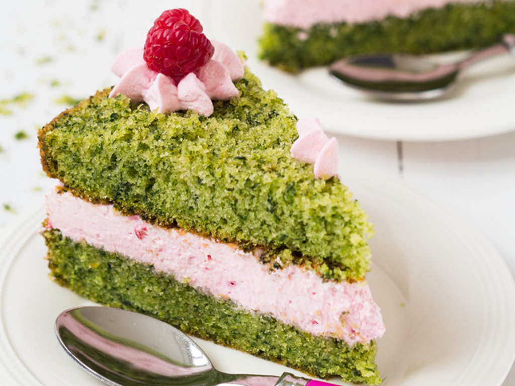 kawałek ciasta leśny mech zielone ciasto ze szpinakiem przełożone kremem malinowym i ozdobione okruszkami z ciasta, kremem i świeżymi malinami - wszystkiego słodkiego