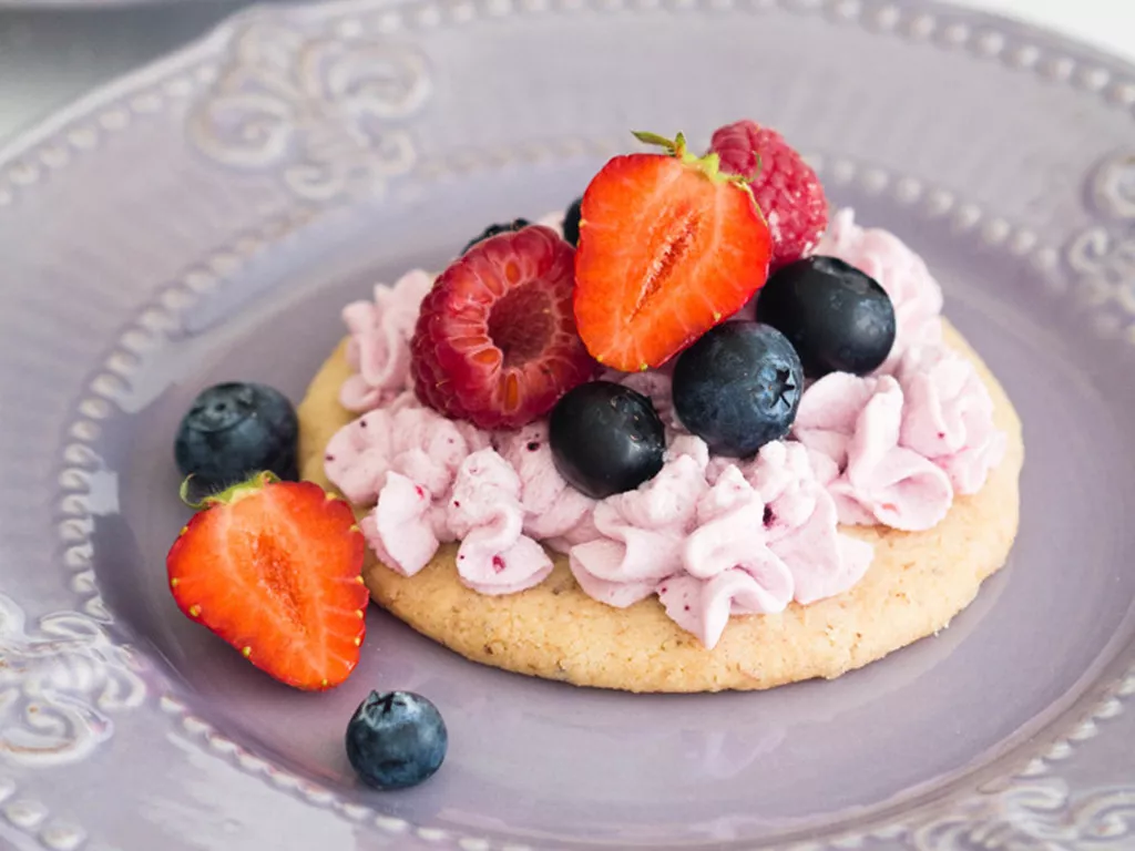 leśny mini deser na migdałowym spodzie z kremem oraz truskawkami, borówkami i migdałami