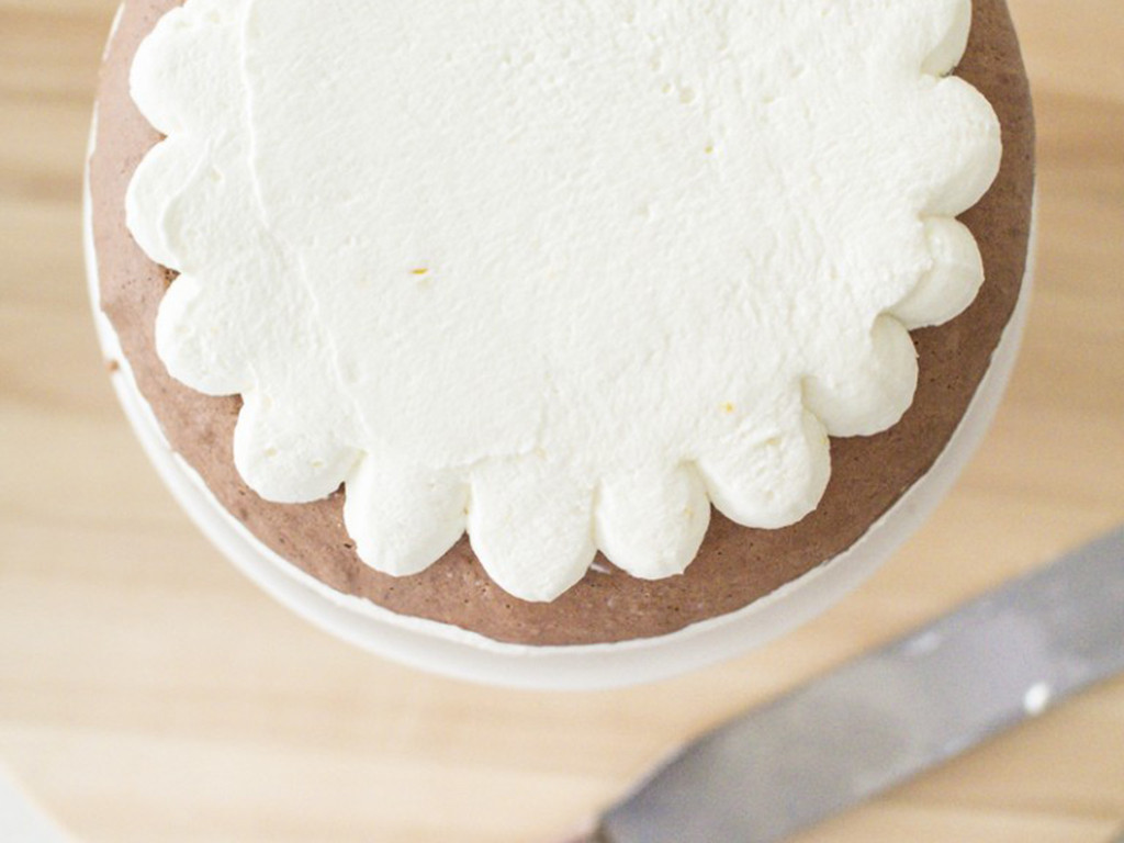 mini torcik udekorowany kremem śmietankowym, który tworzy kształt serwetki