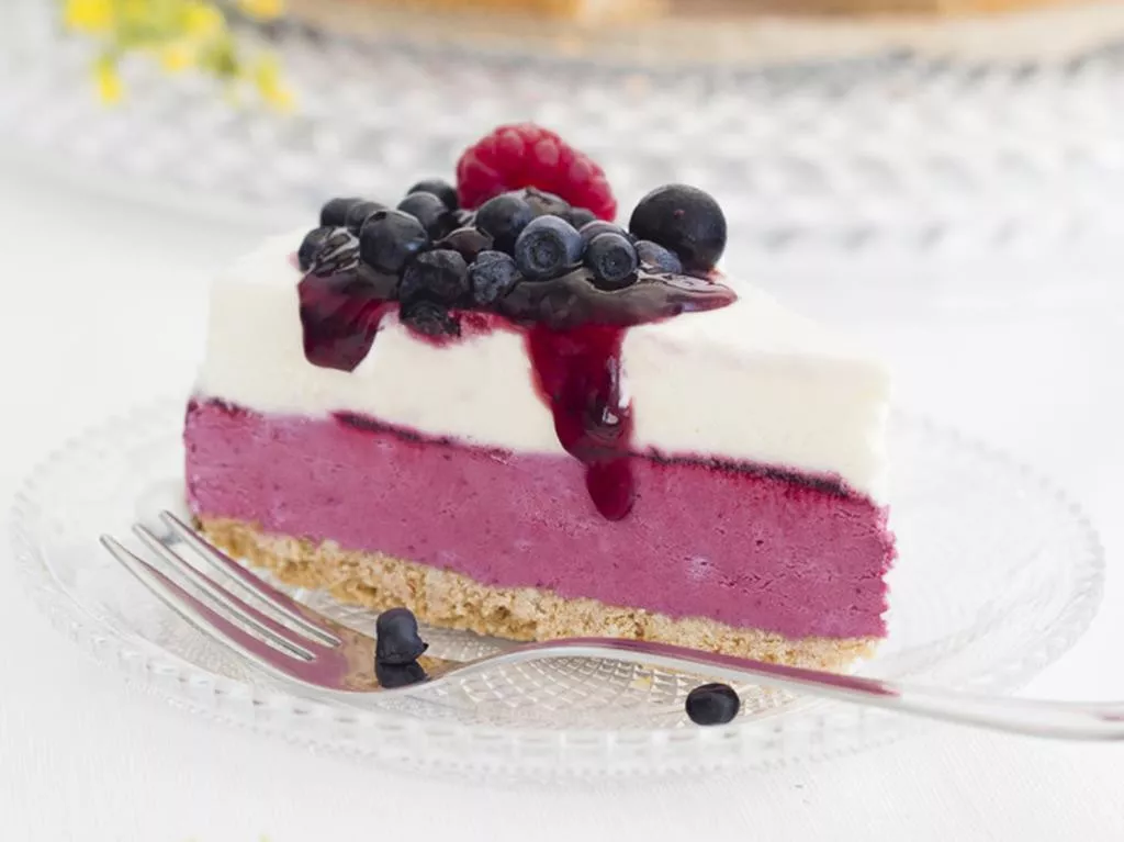 kawałek torcika lodowego śmietankowo-porzeczkowego na spodzie ciasteczkowym z warstwą śmietankowo-porzeczkową oraz śmietankową, podanego ze świeżymi owocami malinami i borówkami oraz sosem owoce leśne dr. oetkera - wszystkiego słodkiego