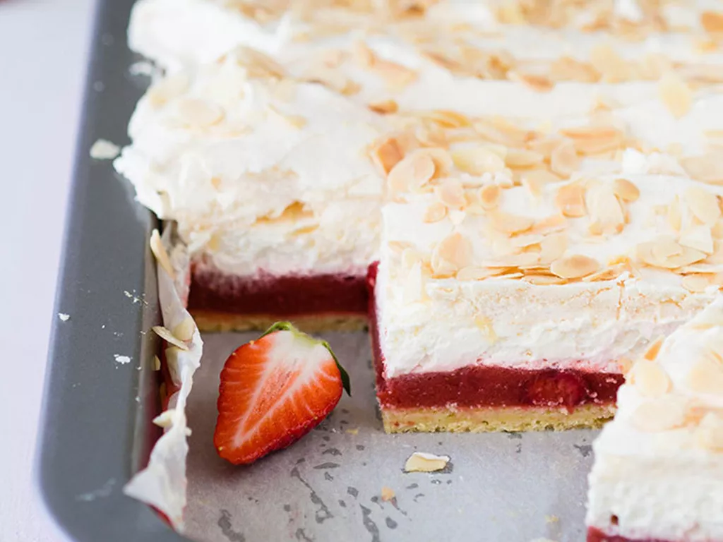 ciasto wiosenne trio na spodzie z ciasta ucieranego, z musem z rabarbaru i truskawek, z bitą śmietaną, bezą i płatkami migdałowymi - wszystkiego słodkiego