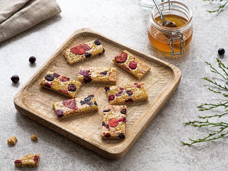 Sezamki z owocami liofilizowanymi na drewnianym talerzyku.
