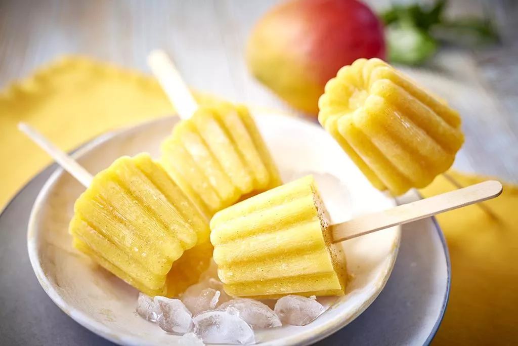 waniliowy sorbet z mango podany na patyczkach i na lodzie