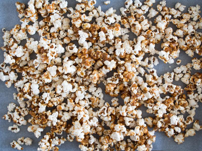 Popcorn w karmelu na blasze z papierem do pieczenia.