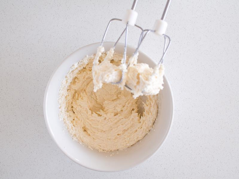 Masło utarte z cukrem w miseczce za pomocą miksera..