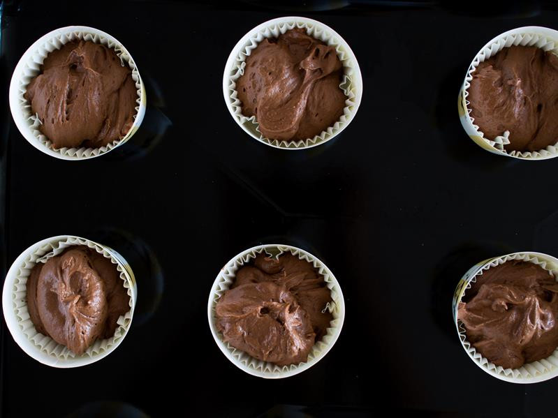 Ciasto na babeczki czekoladowe w papilotkach w formie do pieczenia muffinek.