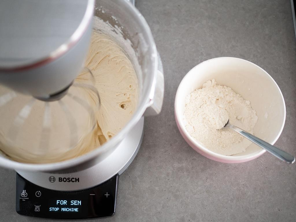 robot kuchenny bosch z ciastem obok miseczka a mąką