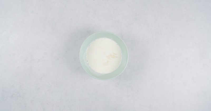 biała czekolada w miseczce zalana gorącą śmietanką