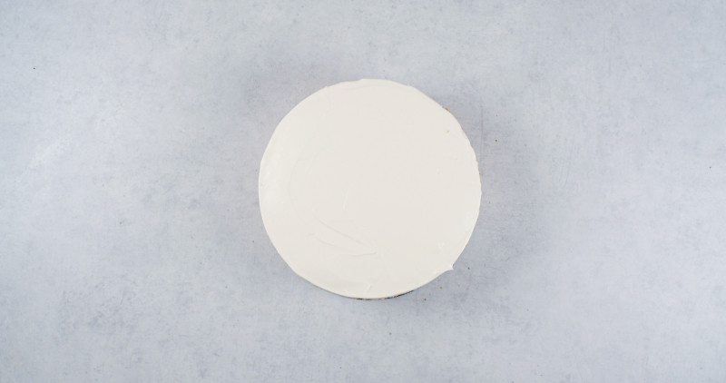 torcik przełożony kremem gruszkowym z rozłożonym na wierzchu kremem z białej czekolady