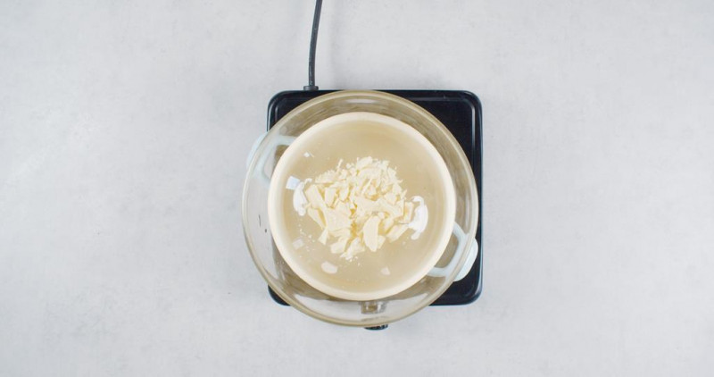 posiekana biała czekolada w misce nad garnkiem z kąpielą wodną