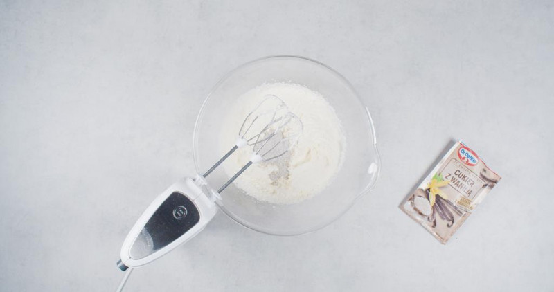 w misce ubita śmietanka, obok cukier z wanilią Dr. Oetkera