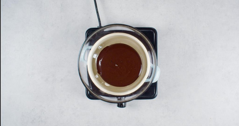 nad garnkiem z gotującą się wodą w szklanej misce rozpuszczona czekolada