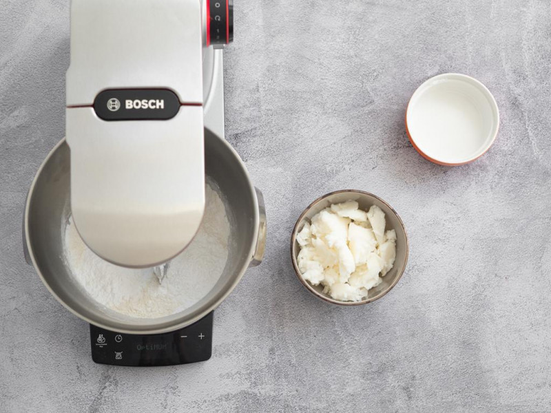 Robot kuchenny MUM firmy Bosch przed zagniataniem ciasta kruchego.. Obok w miseczce olej kokosowy i napój sojowy.