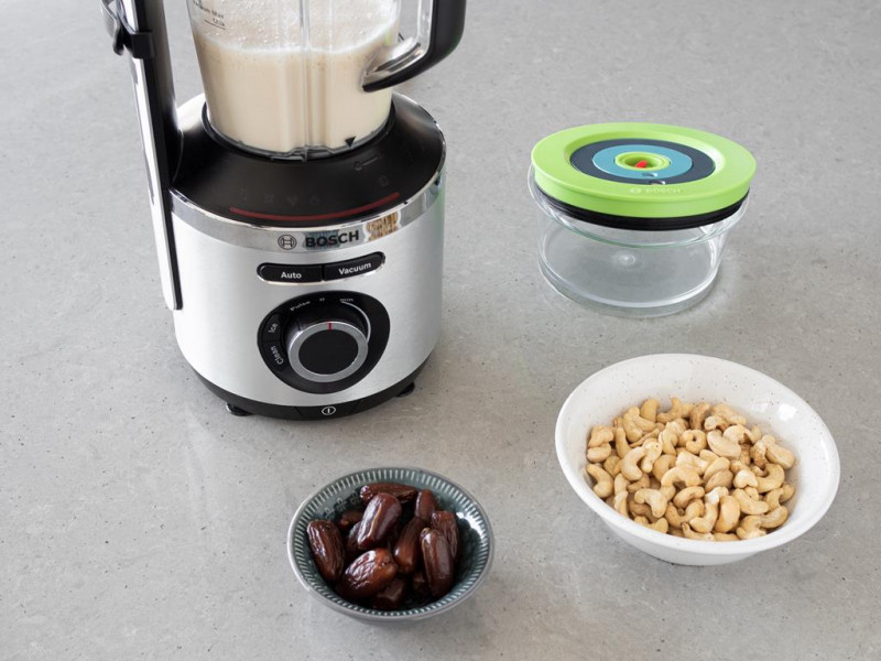 Blender kielichowy Bosch VitaMaxx a obok w miseczkach daktyle i nerkowce.