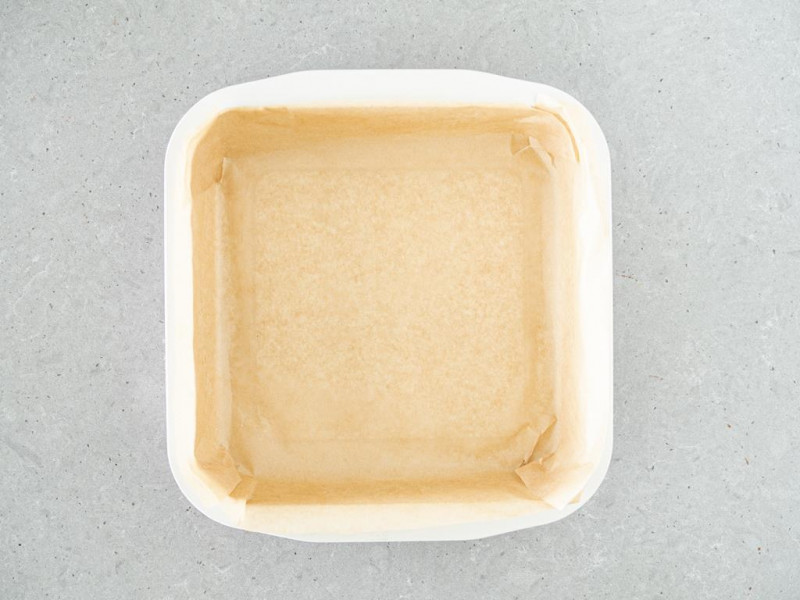 Kwadratowa foremka firmy Dr. Oetker wyłożona papierem do pieczenia.