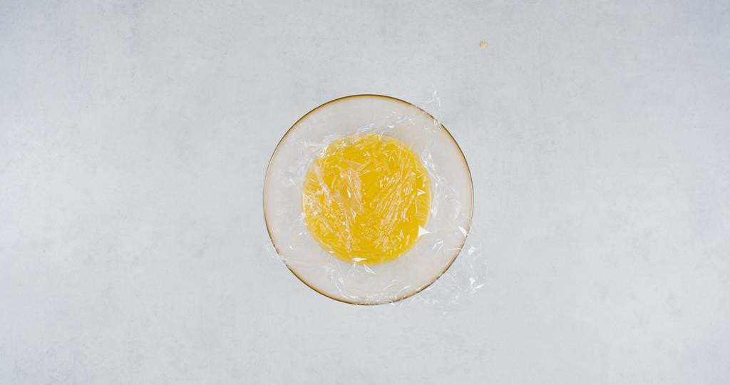 Miska z kremem cytrynowym przykryta folią spożywczą w kontakcie z kremem