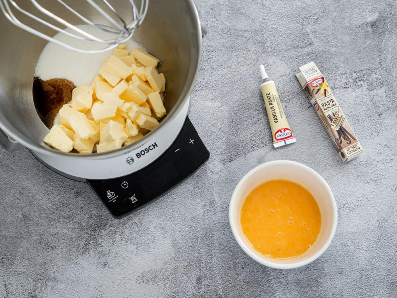 Cukier, masło i pasta z wanilii Dr. Oetker w misie robota kuchennego MUM firmy Bosch. Obok miseczka z żółtkami.