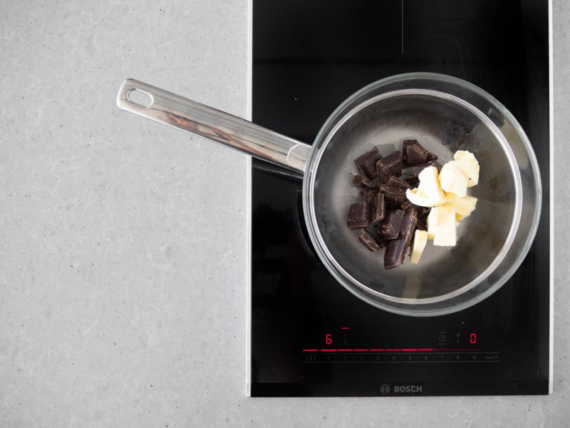 Gorzka czekolada z masłem w garnku, na kuchence indukcyjnej firmy Bosch.