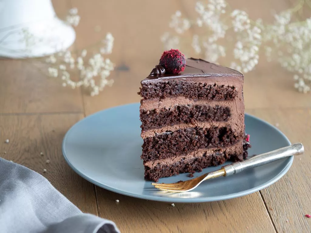 kawałek czekoladowego, wegańskiego tort na szarym talerzyku - Wszystkiego Słodkiego