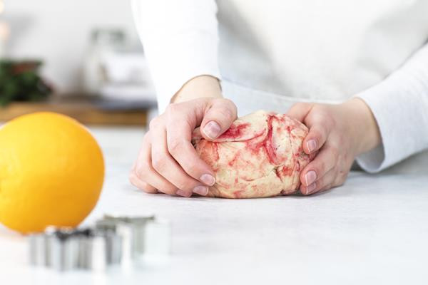 Zagniatanie marcepanu z cukrem pudrem i z czerwonym barwnikiem spożywczym