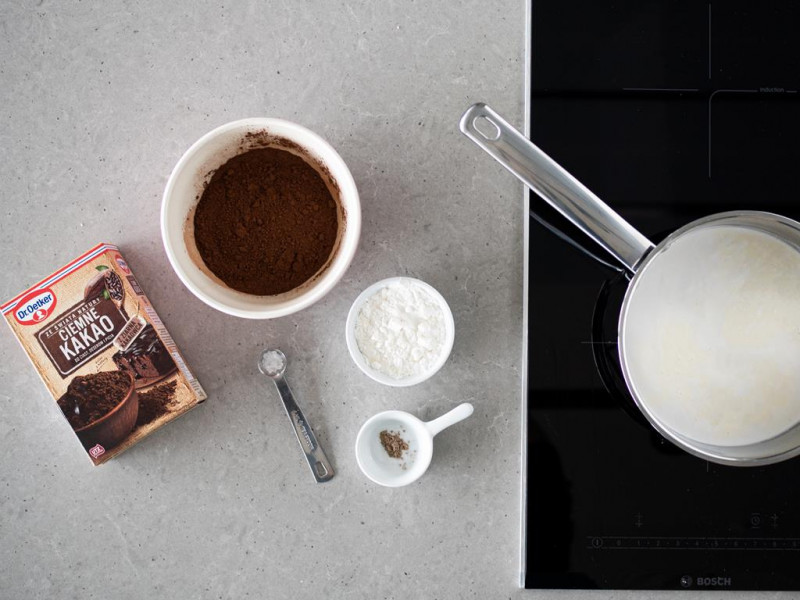 W garnku nap贸j migda艂owy z napojem kokosowym. Obok Ciemne Kakao Dr. Oetkera, skrobia kukurydziana, s贸l oraz kardamon.