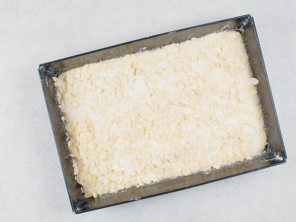 forma z maślanym ciastem drożdżowym posypanym migdałami