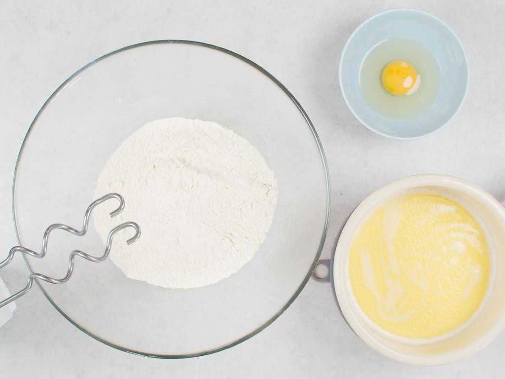 miska z mąką, mleko z masłem i jajko