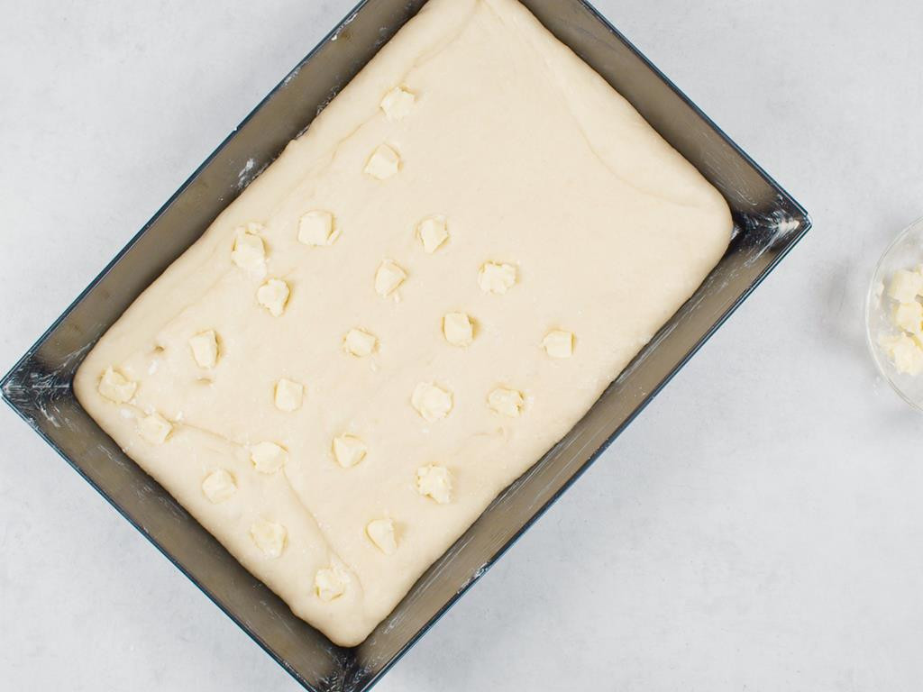 forma z ciastem drożdżowym i powtykanymi w nie kawałkami masła