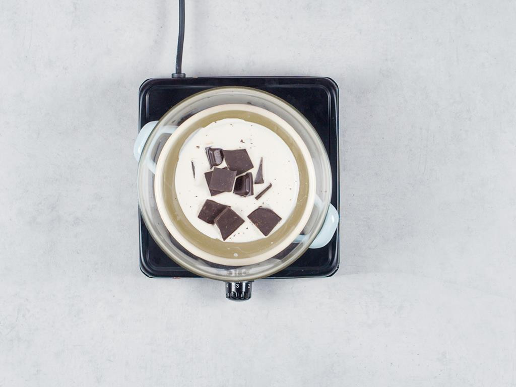 Śmietanka z czekoladą w misce w kąpieli wodnej