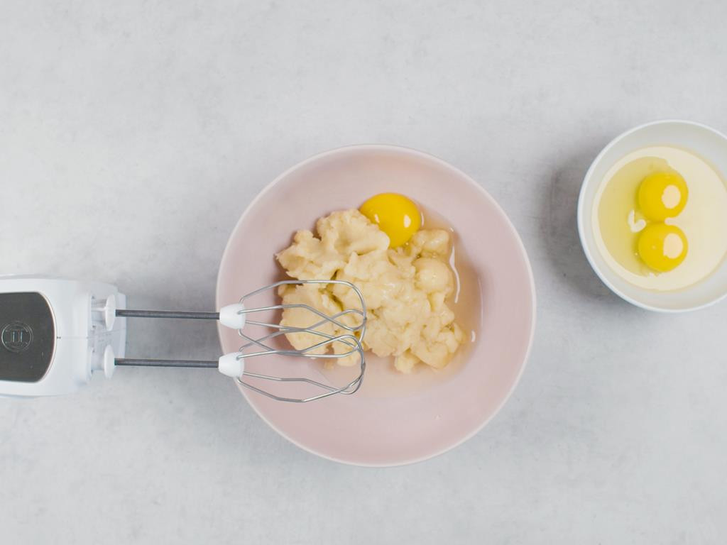 Jajka dodawane do ciasta parzonego na pączki hiszpańskie, jajka w miseczce, mikser