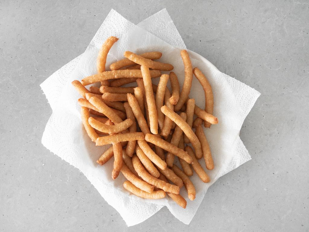 Churros odsączone na ręczniku papierowym.