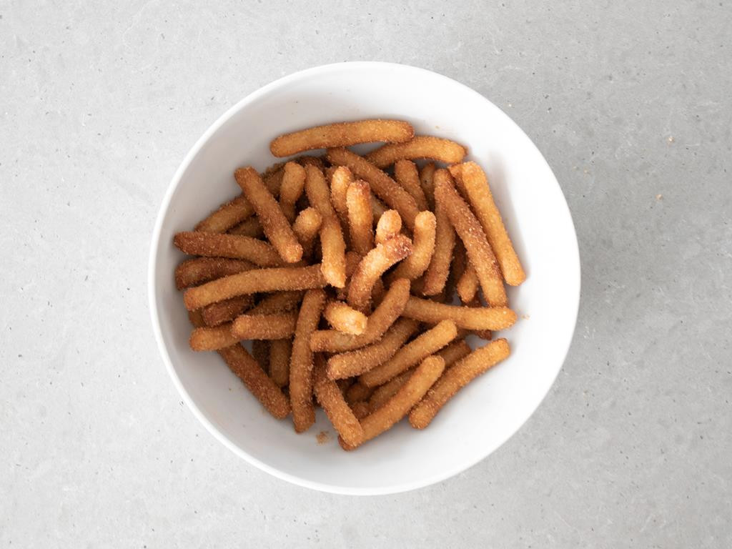 Obtoczone churros w cukrze z cynamonem.