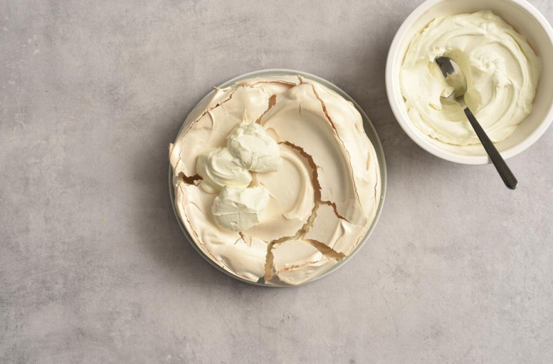 Upieczona beza posmarowana waniliowym kremem.