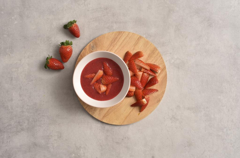 Sos truskawkowy i pokrojone truskawki.
