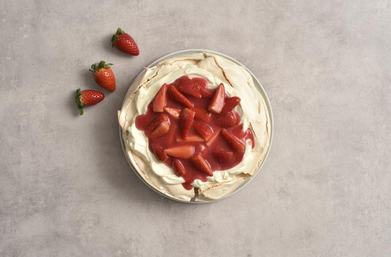 Beza Pavlova z nałożonym kremem i truskawkami.