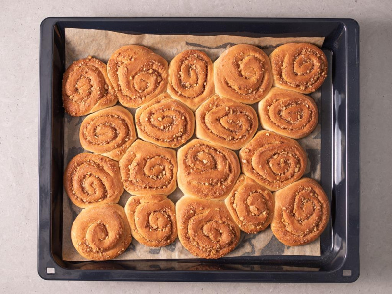 Upieczone wegańskie cynamonki na blasze do pieczenia.