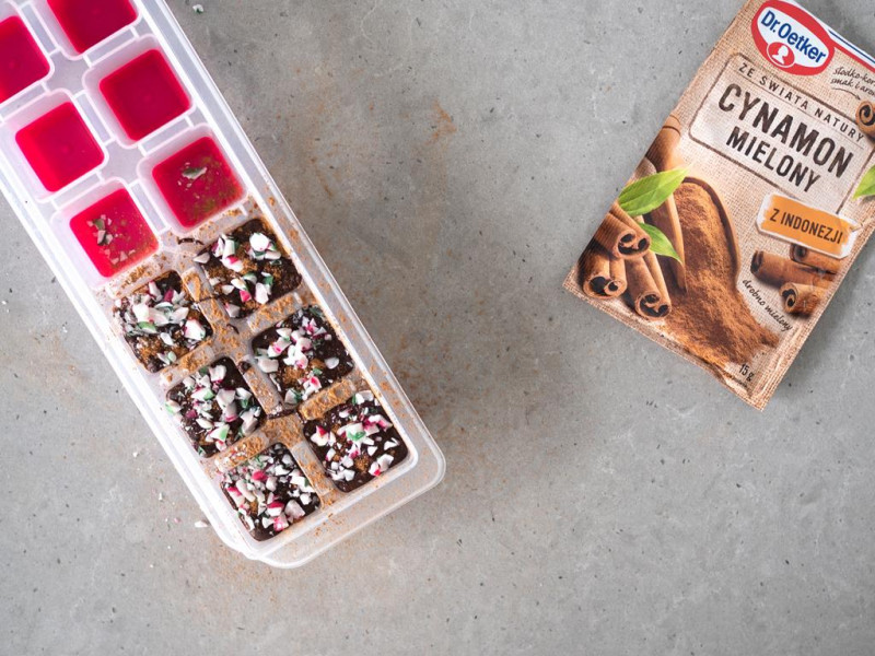 Czekolada obsypana cynamonem i poruszoną laską cukrową.